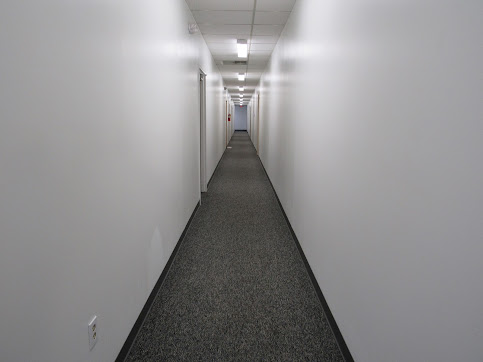 Clean, well-lit interior corridor with fresh carpet